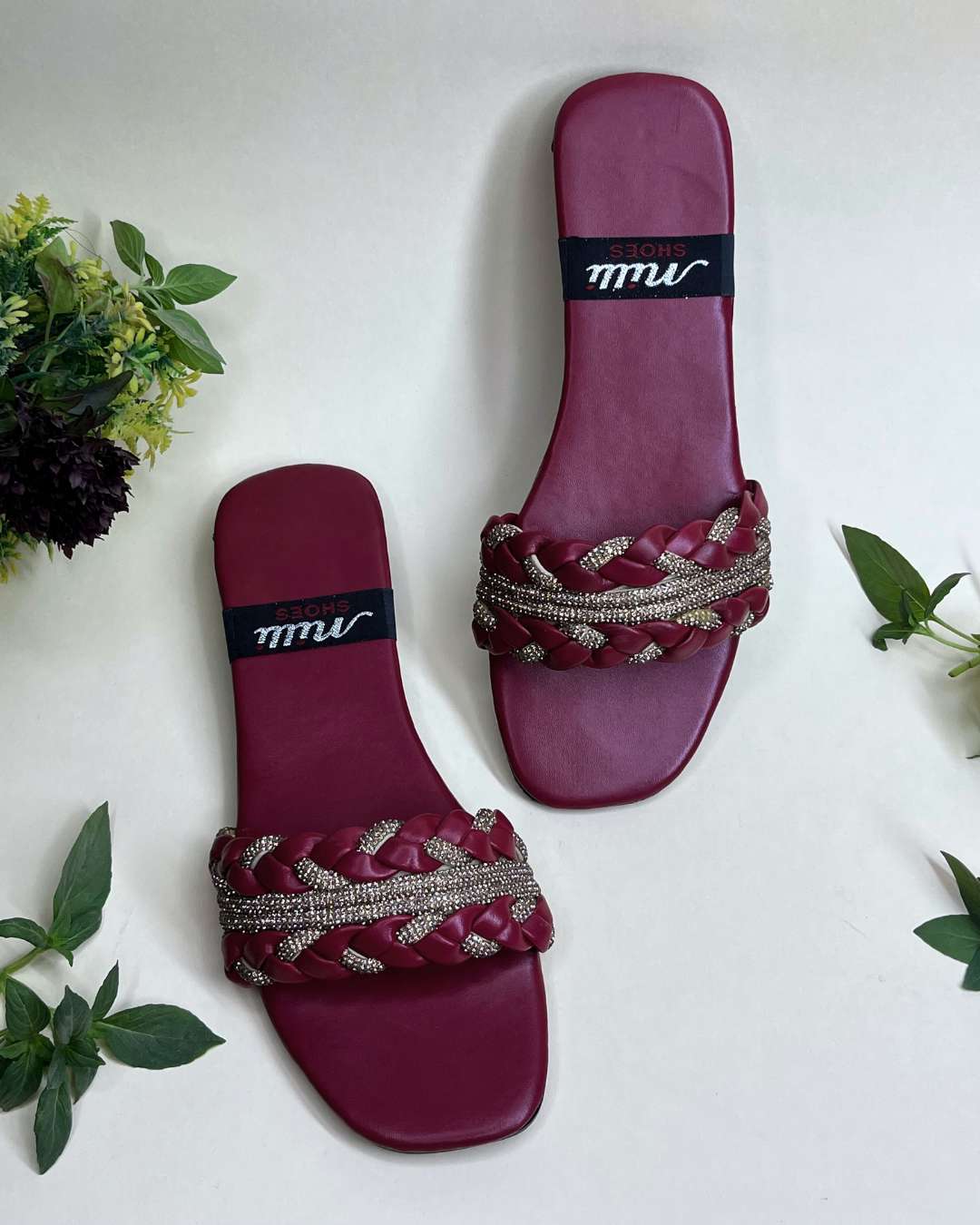 Elegant braided women flats featuring crystal accents on a neutral background