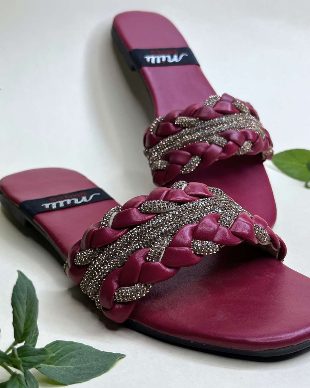 Elegant braided women flats featuring crystal accents on a neutral background