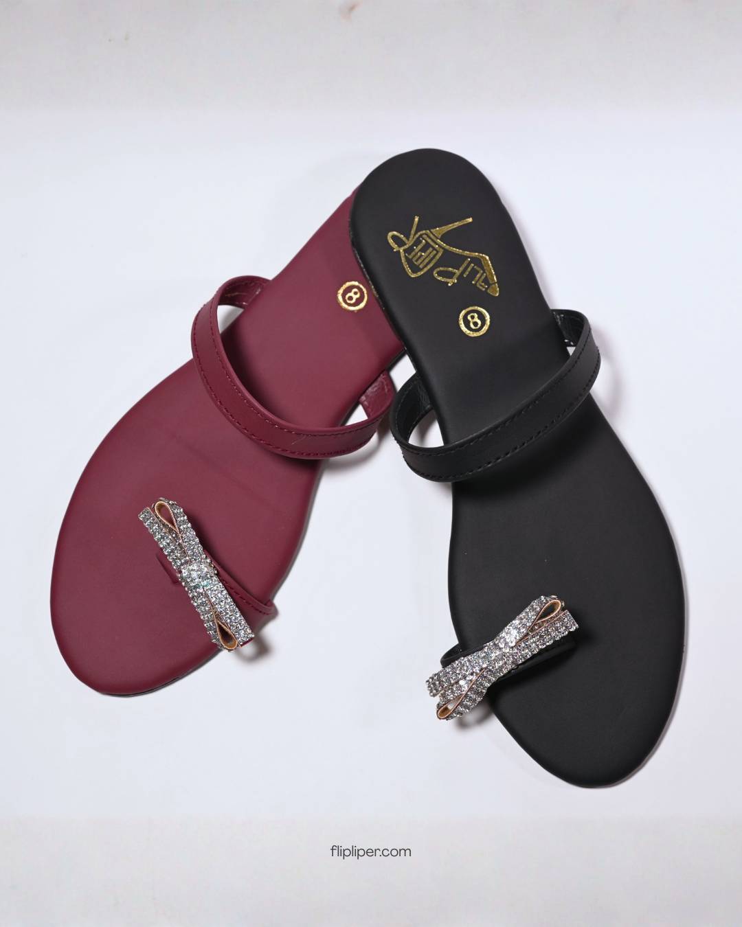 Red sandals with crystal embellishments displayed on a dark black background
