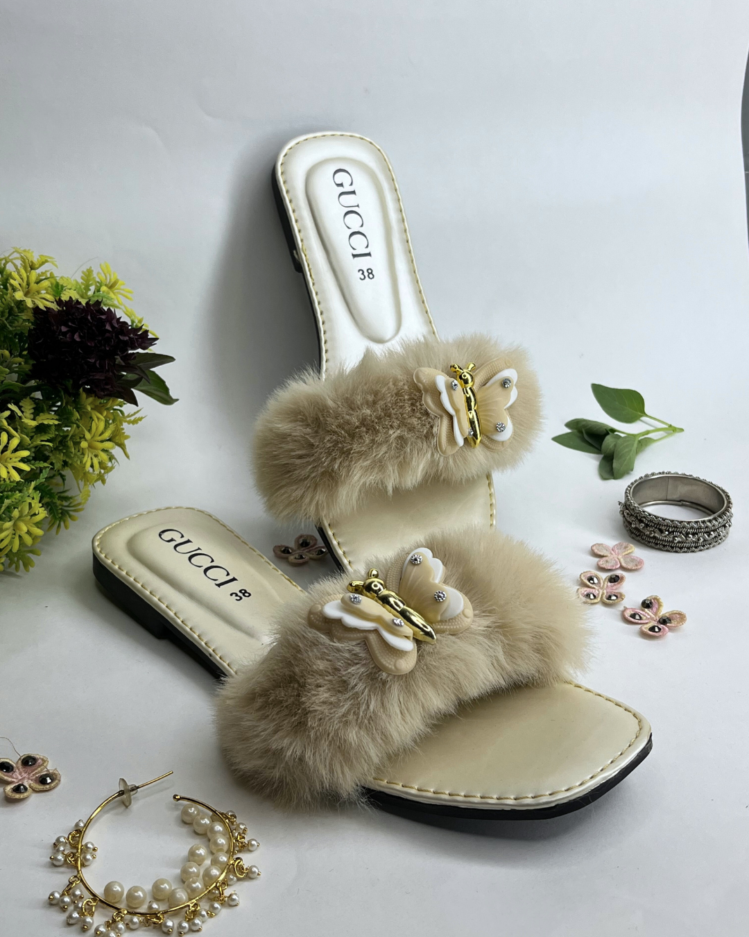 Women comfort slides with fluffy fur strap and butterfly embellishment on a light background
