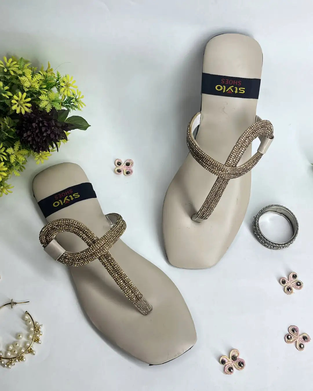 Women elegant flats with crystal loop strap design on a light background