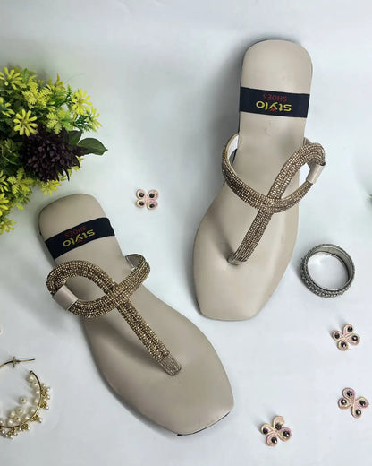 Women elegant flats with crystal loop strap design on a light background