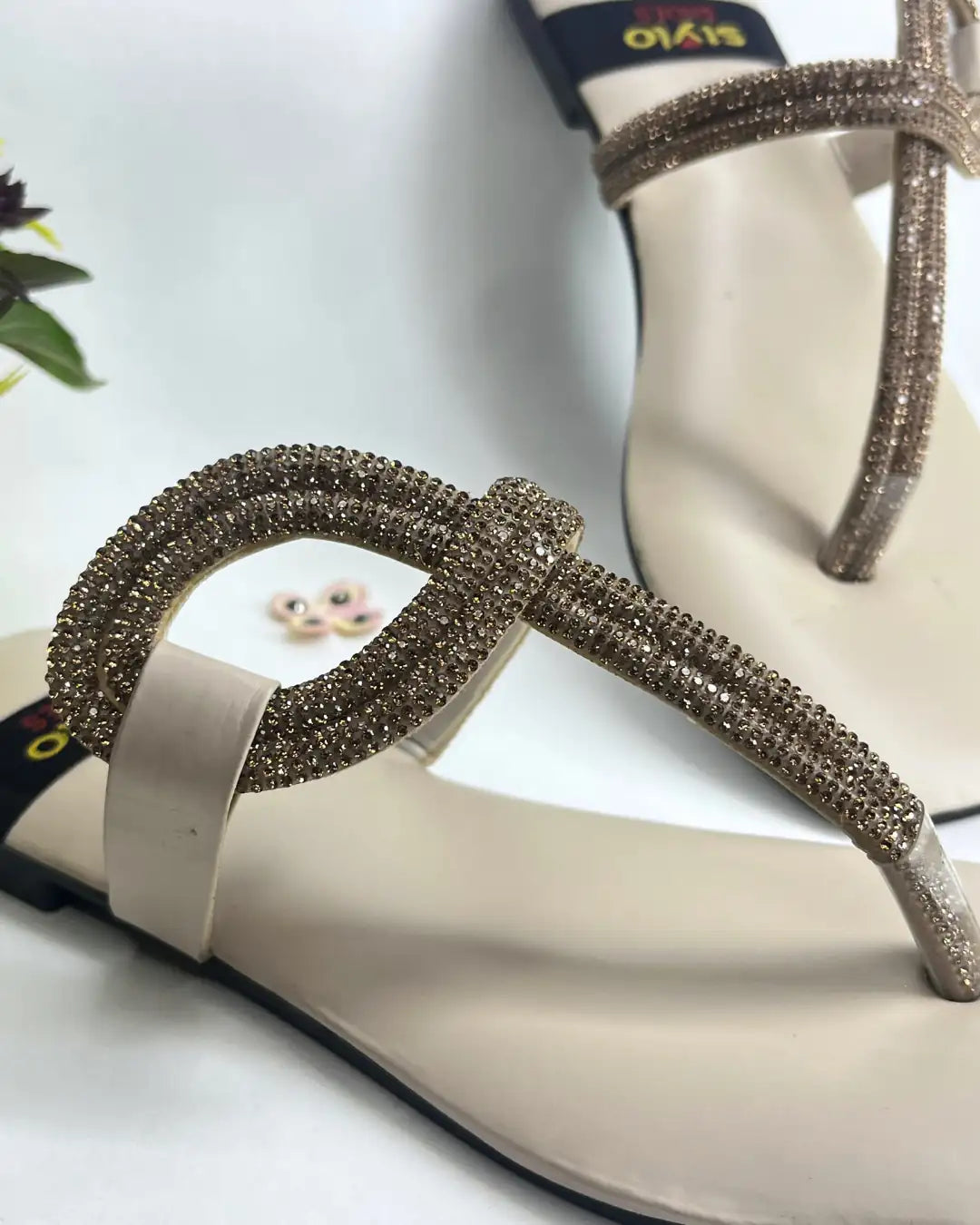 Women elegant flats with crystal loop strap design on a light background