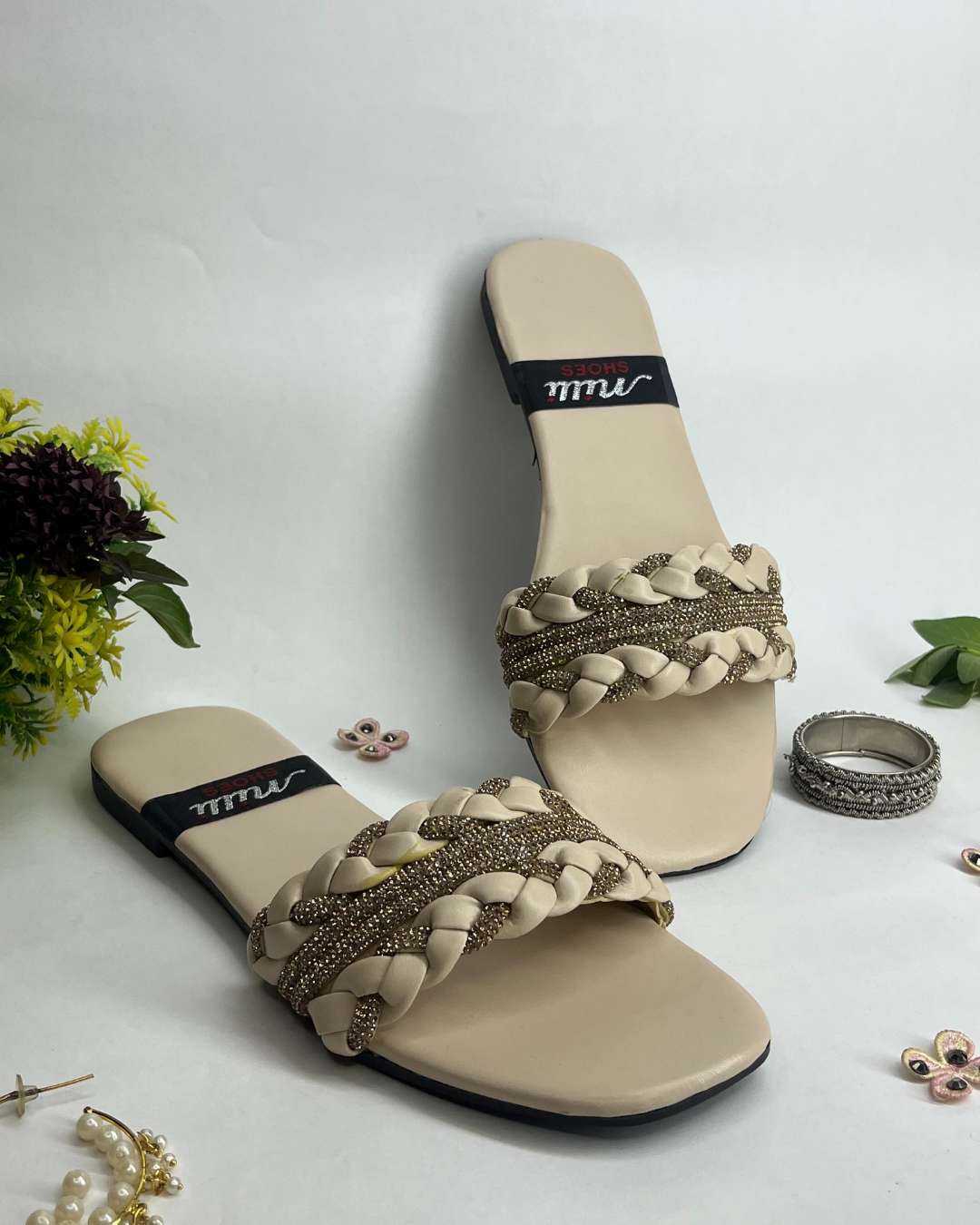 Women braided flats with crystal detailing and elegant design on a light background