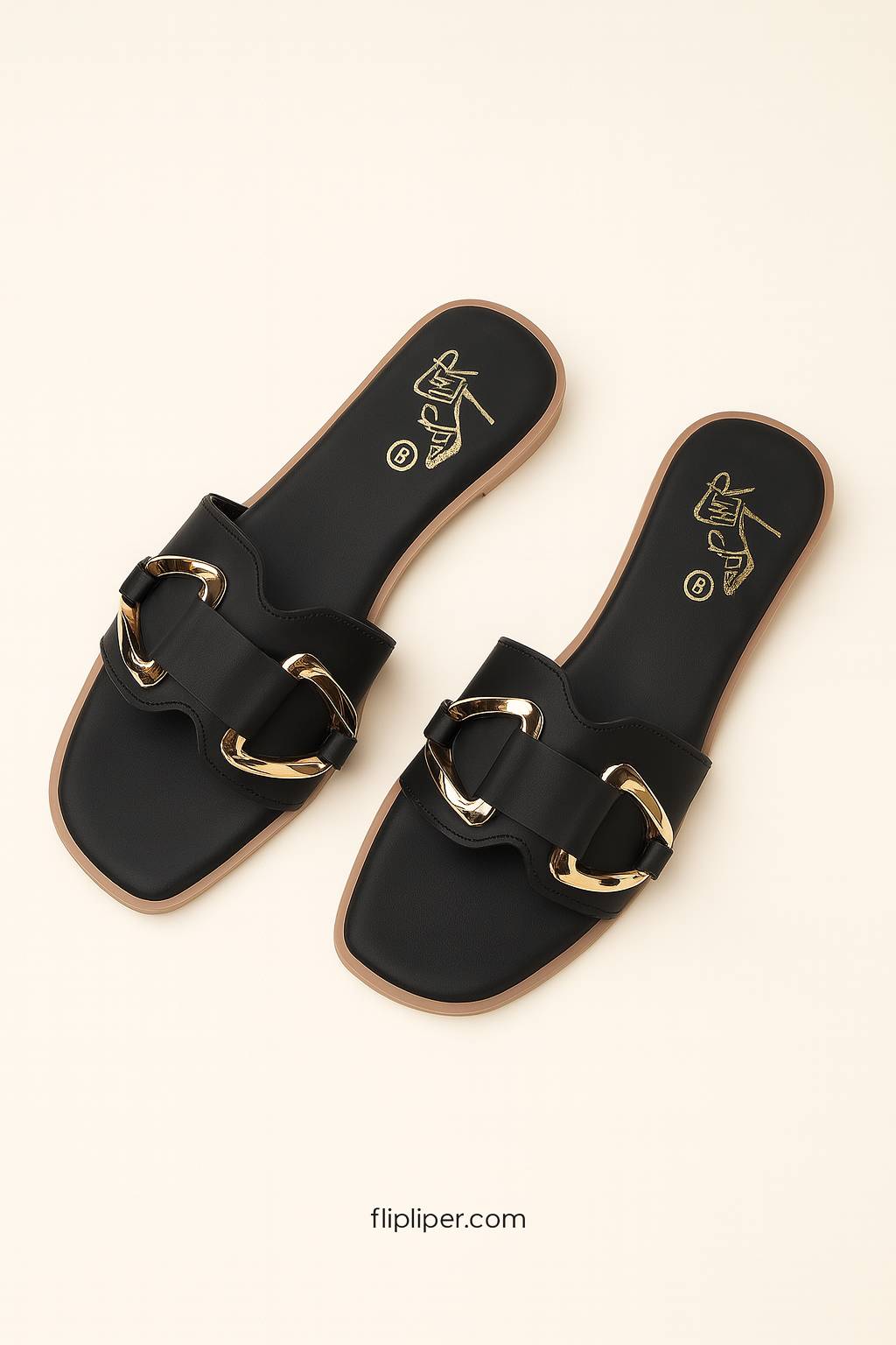 Pair of black sandals with gold buckles displayed on a beige background
