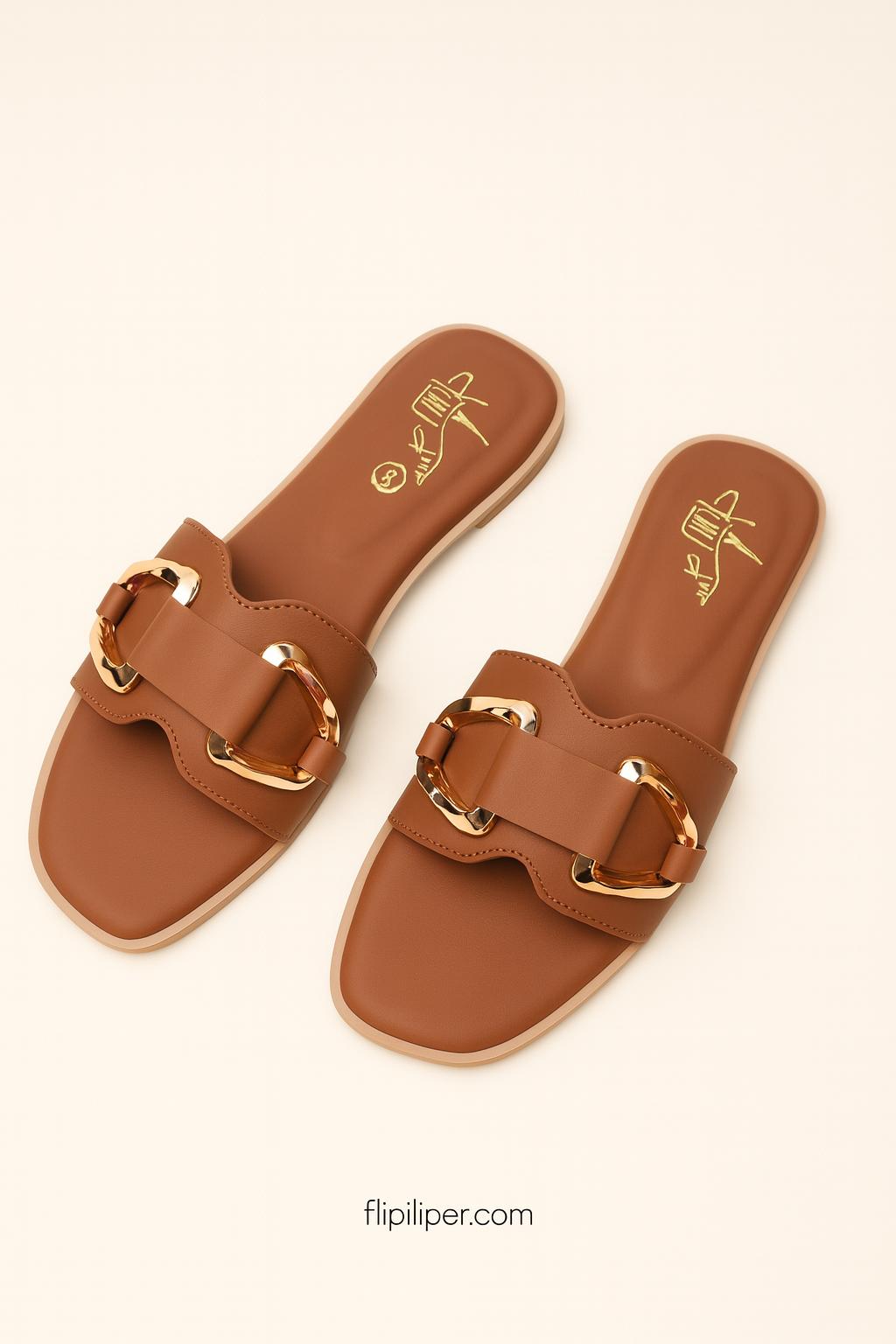 Pair of brown sandals with gold buckles displayed on a beige background
