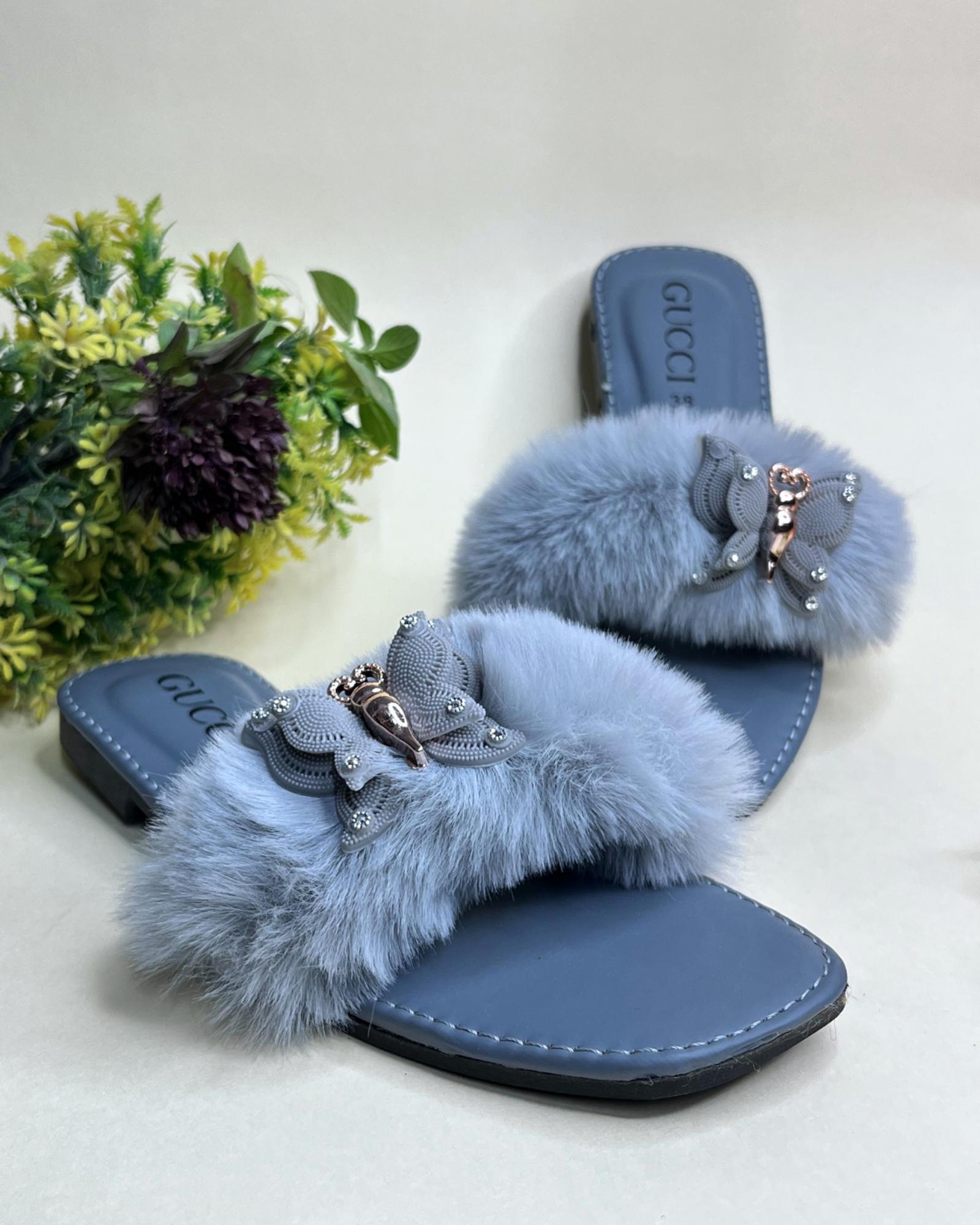 Blue Gucci style fluffy fur strap women slides with metallic detail on a light background
